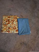Both fabric pieces folded side by side on carpet