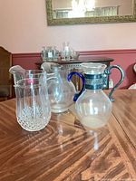 Three pitchers on table showing relative sizes and features