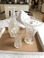 Overall view of three crystal pieces: decanter, medium vase, small vase
