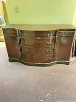 Full front view of dark mahogany sideboard buffet with serpentine drawers and side cabinets