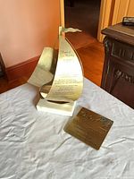 Sailboat sculpture and plaque together on table