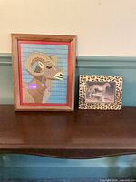 Both framed art pieces together on table