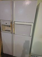 Front view of white GE side-by-side refrigerator with ice/water dispenser
