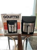 Front view of air fryer next to original box
