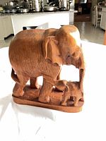 front view of solid-wood elephant with calf carving