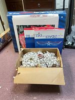 All items together: boxed rope light horse, boxed flag window set, boxed star swag, open box of string lights