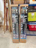 Two boxed HomeScape 85-inch upright posts standing side by side