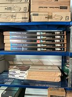 Stack of five boxed HomeScape adjustable shelves on rack
