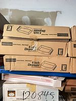 Stacked brown cartons labeled HomeScape 4 inch Drawer Module E