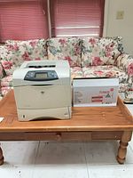 Front view of HP LaserJet 4240n printer with boxed toner cartridge