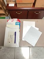 Group view: HP brochure paper box, sealed Tektronix pack, loose glossy and patterned sheets