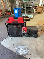 Tool bag with tags beside two hard cases
