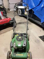 Full view of John Deere mower from front showing deck, wheels, handle