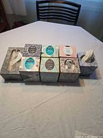 Eight tissue boxes side-by-side showing assorted designs and mixed fill levels