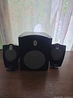 Front view of subwoofer flanked by two satellite speakers