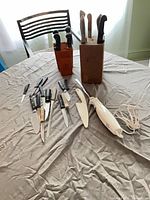 Overall view of both knife blocks, loose knives, electric carving knife and sheaths on table