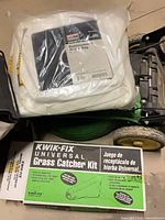 Kwik-Fix kit box, sealed replacement bag visible on mower deck