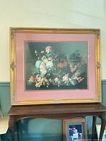 Full view of framed floral still life print on stand