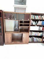 Front view of entertainment center showing glass-door uppers, open middle, lower cabinets