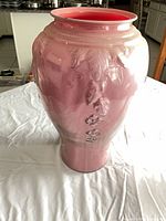 Full view of pink glass floor vase showing glossy finish and relief floral decoration