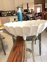 Side view showing scalloped rim and three feet