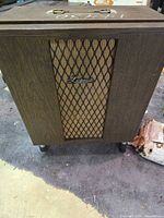 Front view showing wood cabinet, grille and logo
