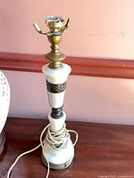 Stacked ceramic, brass and marble lamp base with cord visible