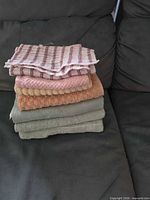 Stack of five towels showing varied colors and textures