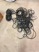 Overall view of tangled bundle of black audio cables on floor