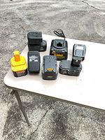 Overall view of seven battery packs and two chargers on table