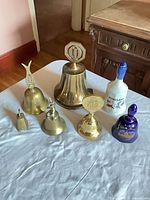 Group view of seven brass and porcelain bells