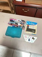 Full lot overview showing bag of pens, Bazic dry erase set, pencil box, triangular erasers