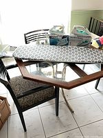 Ironing board with patterned cover, two boxed irons on table