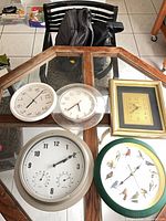 Five wall clocks arranged on glass table