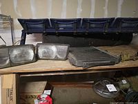 Headlights, radiator, VW hubcap and other parts on shelf