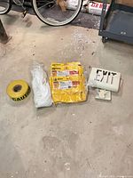 Group view of rope coil, caution tape roll, three caddy bags, exit sign with mount