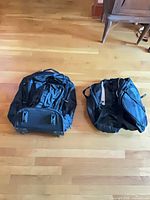 Pair of black Lucas rolling duffel bags showing overall condition