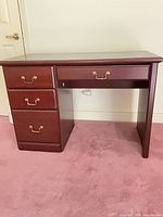 Front view of mahogany desk showing all drawers closed