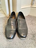 Front view of loafers showing synthetic black uppers and vamp strap