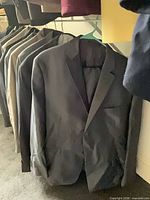 Black blazer on hanger with others behind
