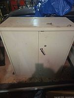 Front view of beige metal cabinet showing two doors and lock handle