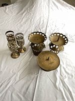 Group shot of three goblets and three candle holders on white cloth