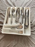 Full view of cutlery tray with mixed stainless utensils