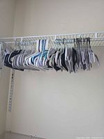Closet rod holding mixed grey, black, white and turquoise accented hangers