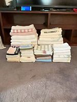 full lot of folded towels showing variety of sizes and colours