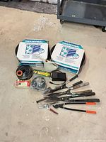 Group shot of all items including edging rolls, tools, watering can, transformer and spools
