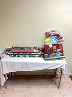 table with wrapping paper rolls, gift bags, bag of bows