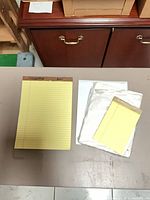 Yellow legal pad, sealed loose paper stack, steno pad