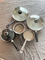 Group view of all five pans and three lids