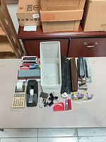 Entire lot laid out showing organizer, calculator, staplers, hole punch, tape dispenser, staples, clips, tape